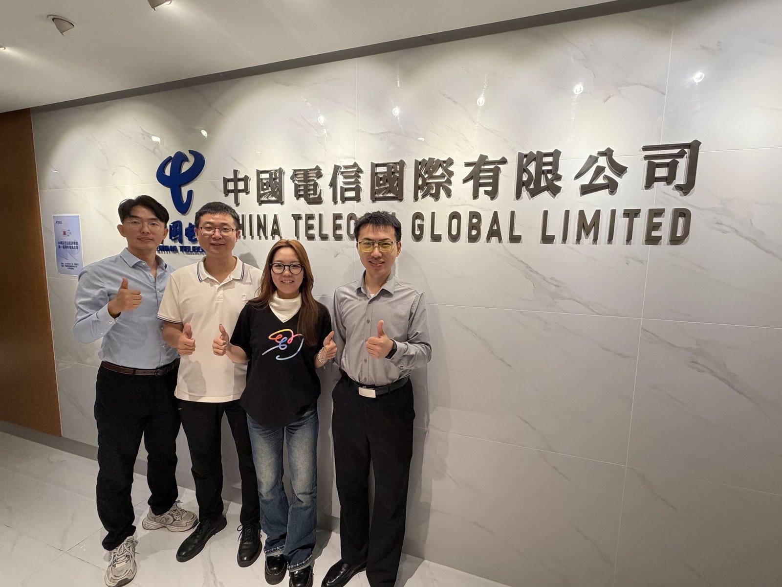 天成与张阳、张财华在客户 logo 墙前合影